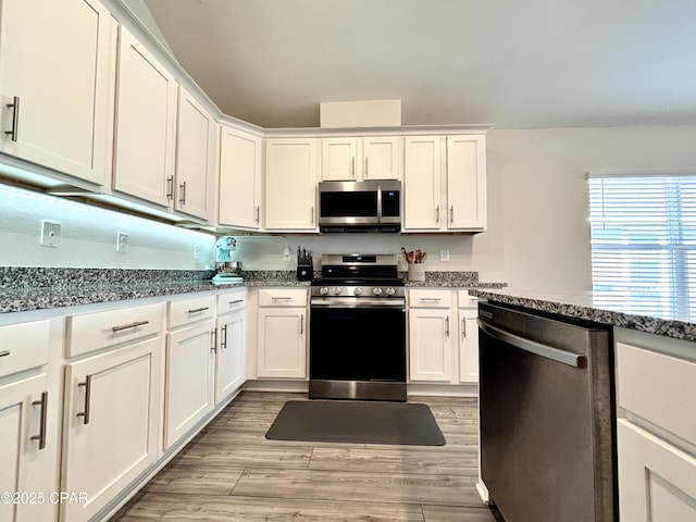 kitchen featuring appliances with stainless steel finishes, white cabinets, and light wood-style floors