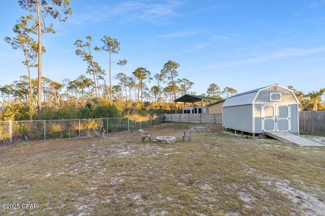 132 Gulf Terrace Ln, Port St Joe, FL 32456 - fenced backyard featuring a fire pit, a storage unit, and an outdoor structure