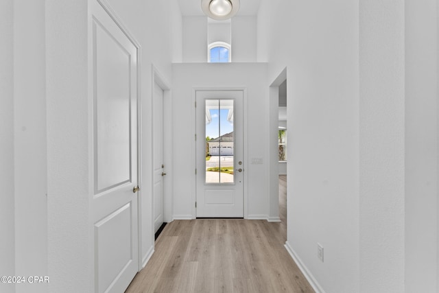 doorway with light wood-type flooring and baseboards