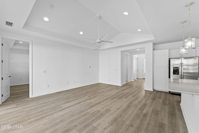 unfurnished living room with ceiling fan, light wood-type flooring, visible vents, recessed lighting, and a raised ceiling