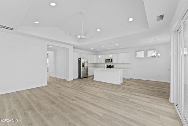 kitchen with open floor plan, appliances with stainless steel finishes, a tray ceiling, and visible vents