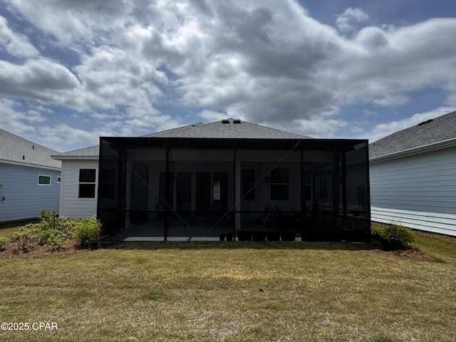 rear view of house featuring a patio area, glass enclosure, a lawn, and roof with shingles