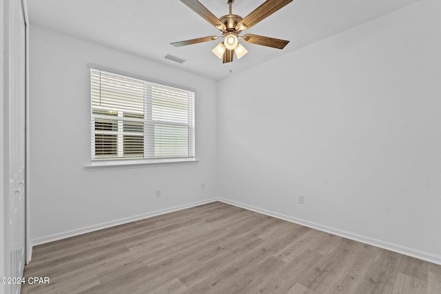 unfurnished room featuring visible vents, baseboards, a ceiling fan, and light wood-style flooring