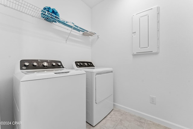 laundry area featuring light tile patterned floors, baseboards, electric panel, laundry area, and washing machine and dryer