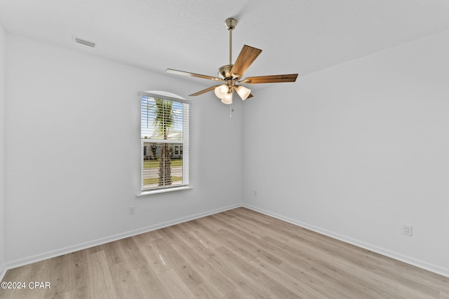 empty room with visible vents, baseboards, a ceiling fan, and light wood-style floors