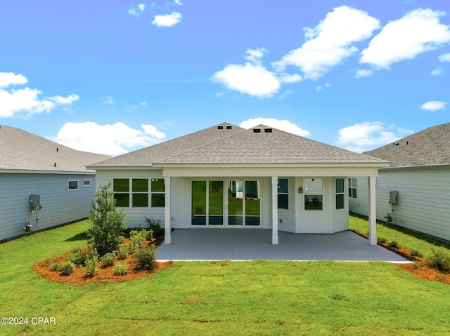 back of house featuring a lawn, a patio, and a shingled roof