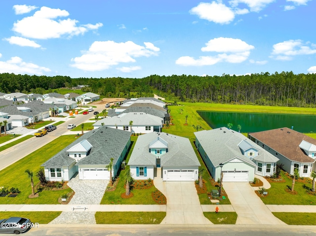 drone / aerial view with a water view, a view of trees, and a residential view