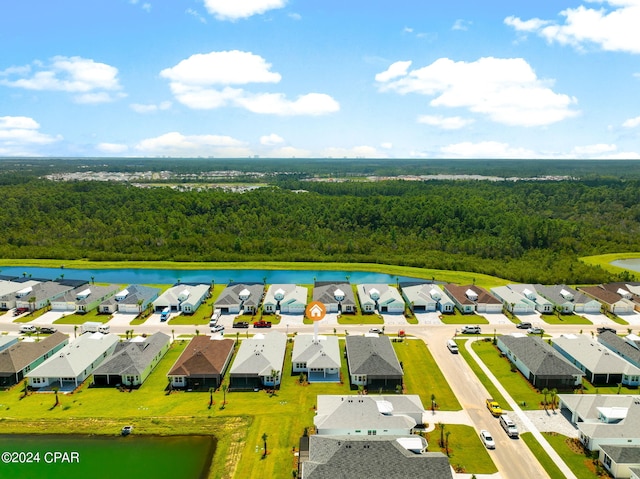 aerial view with a wooded view, a residential view, and a water view