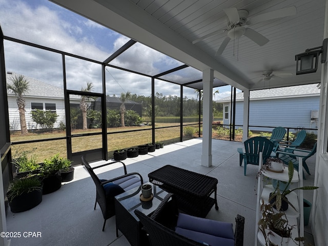 view of patio featuring ceiling fan and glass enclosure