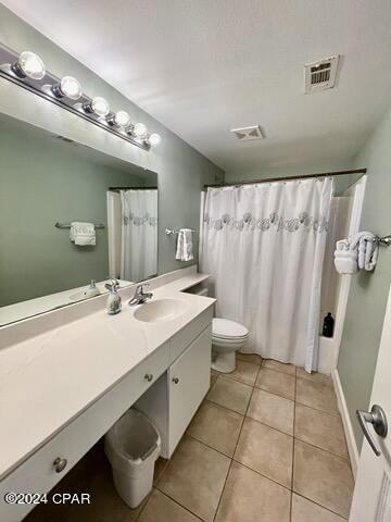 bathroom with tile patterned floors, toilet, curtained shower, and vanity