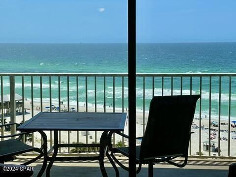 balcony featuring a beach view and a water view