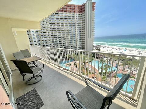 balcony featuring a view of the beach and a water view