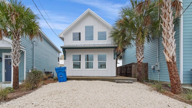 exterior space featuring fence, metal roof, and board and batten siding