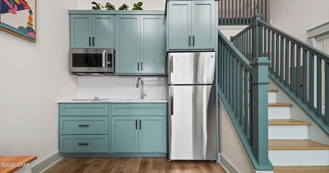 kitchen featuring tasteful backsplash, stainless steel appliances, dark hardwood / wood-style flooring, and sink