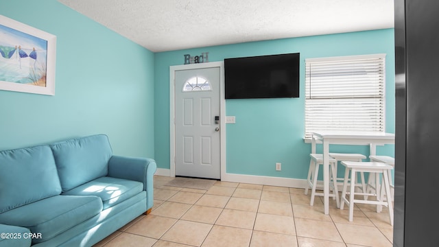 tiled entryway with a textured ceiling