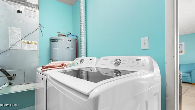 laundry room featuring heating unit, water heater, washing machine and clothes dryer, and light tile patterned floors