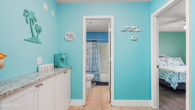 full bathroom with tile patterned flooring, toilet, ceiling fan, shower / bathtub combination with curtain, and vanity