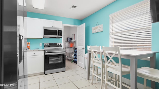 kitchen featuring appliances with stainless steel finishes, white cabinetry, and light tile patterned floors