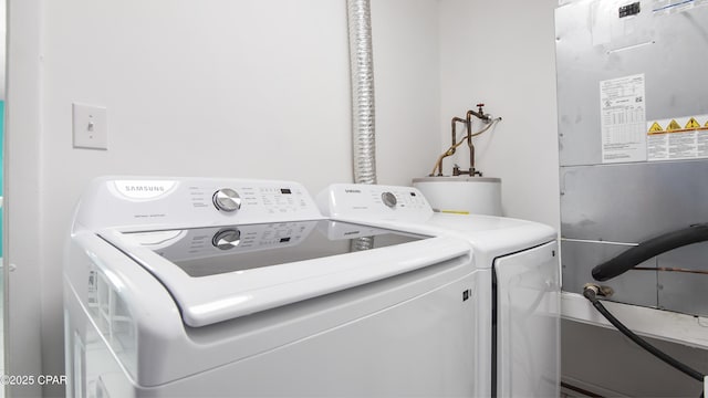 laundry room with washing machine and clothes dryer and water heater