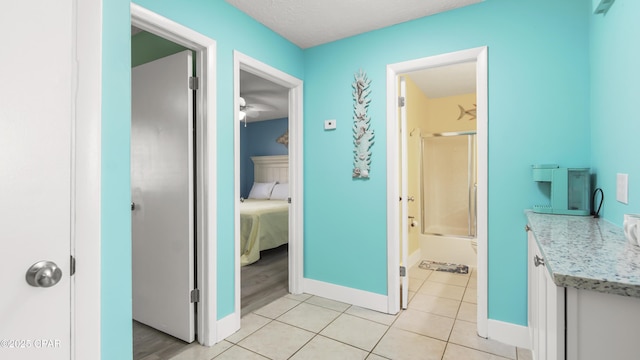 bathroom featuring tile patterned flooring, vanity, and combined bath / shower with glass door