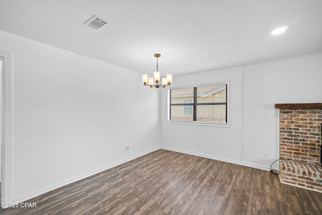 unfurnished living room with an inviting chandelier and dark wood-type flooring