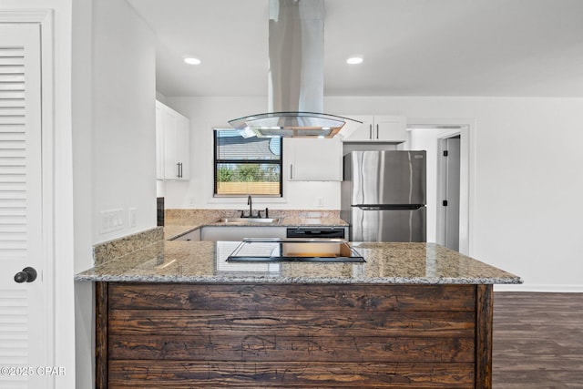 kitchen featuring white cabinets, sink, stainless steel fridge, and island exhaust hood