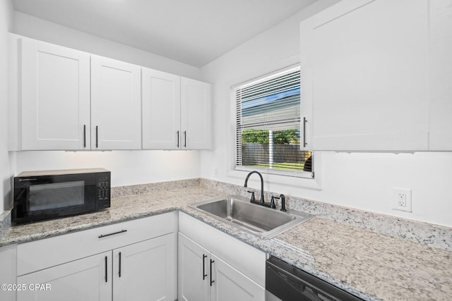 kitchen featuring white cabinetry, sink, light stone counters, and dishwashing machine