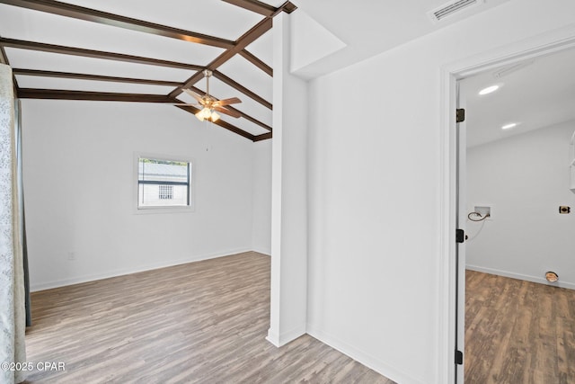 empty room with ceiling fan, light hardwood / wood-style floors, and vaulted ceiling with beams