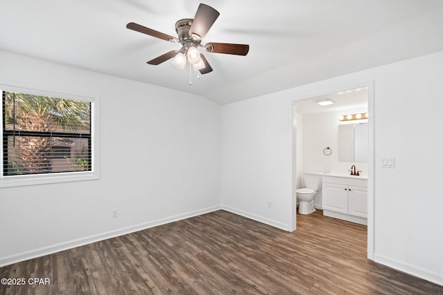 unfurnished bedroom featuring vaulted ceiling, ensuite bath, sink, ceiling fan, and dark hardwood / wood-style flooring