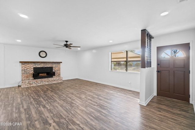 unfurnished living room featuring ceiling fan, dark hardwood / wood-style floors, and a fireplace