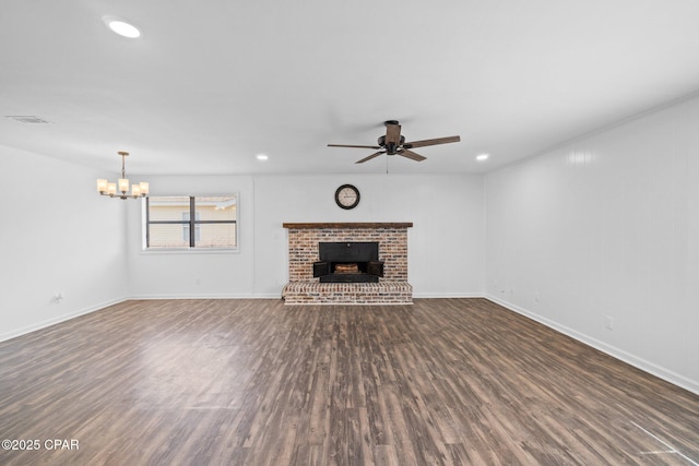 unfurnished living room featuring ceiling fan with notable chandelier, dark hardwood / wood-style floors, and a fireplace