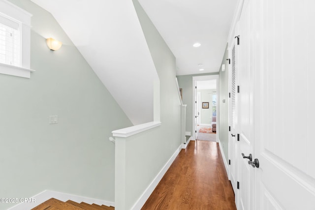 corridor featuring baseboards, recessed lighting, and wood finished floors