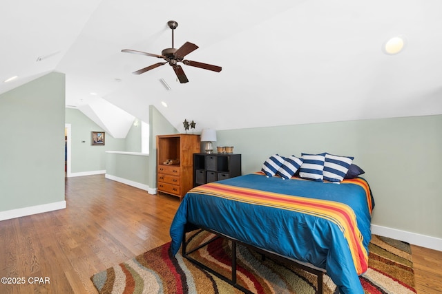bedroom with wood finished floors, ceiling fan, baseboards, and lofted ceiling