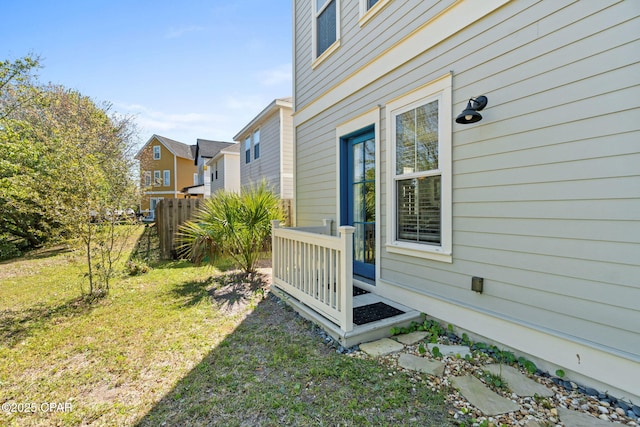 view of side of property featuring a residential view, fence, and a lawn