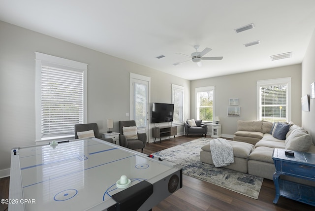 living room with dark wood-type flooring and ceiling fan