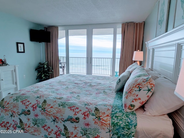 bedroom with a textured ceiling and access to exterior