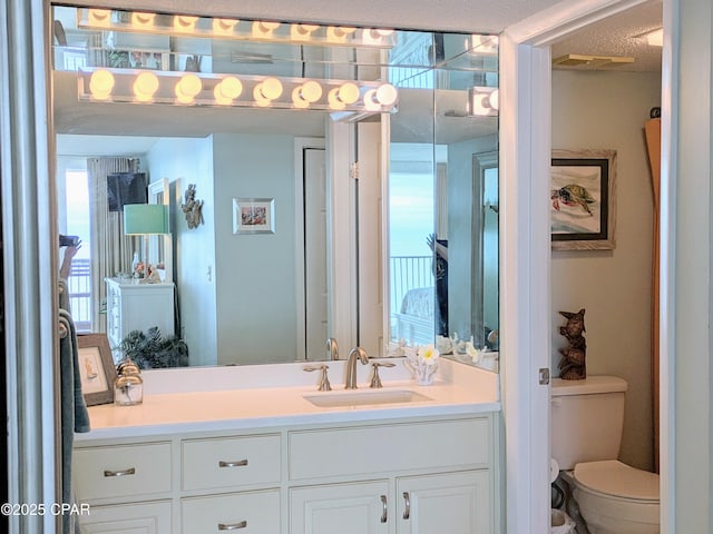 bathroom with visible vents, vanity, and toilet