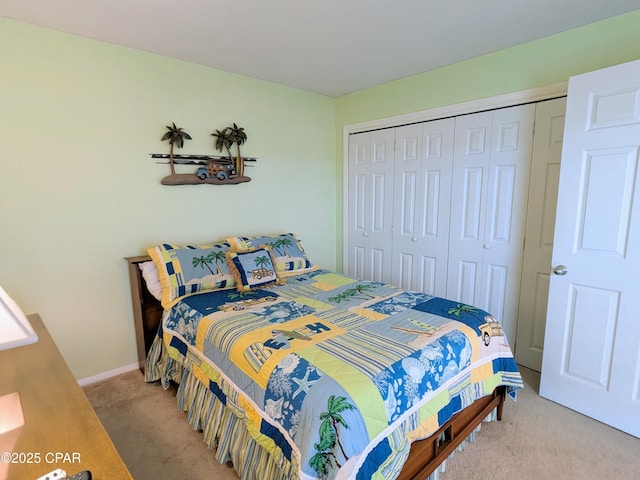 bedroom with carpet, baseboards, and a closet