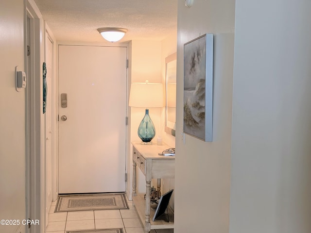 hall with light tile patterned floors and a textured ceiling