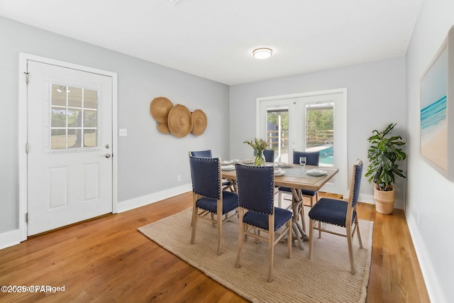 dining area with hardwood / wood-style floors and french doors