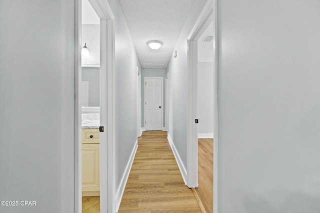 hallway with wood-type flooring and a textured ceiling