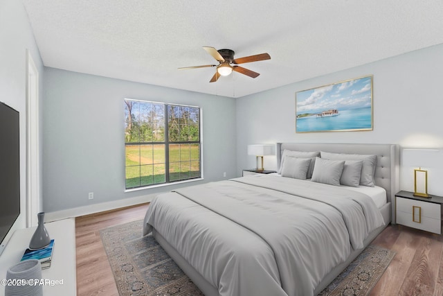 bedroom featuring wood-type flooring, ceiling fan, and a textured ceiling