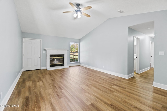 unfurnished living room with a fireplace, vaulted ceiling, wood-type flooring, and ceiling fan