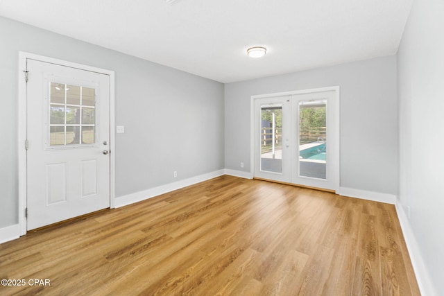 unfurnished room with light hardwood / wood-style flooring and french doors