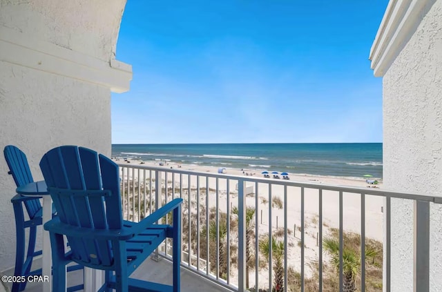 balcony with a water view and a beach view