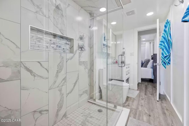 bathroom featuring a marble finish shower, visible vents, toilet, connected bathroom, and wood finished floors