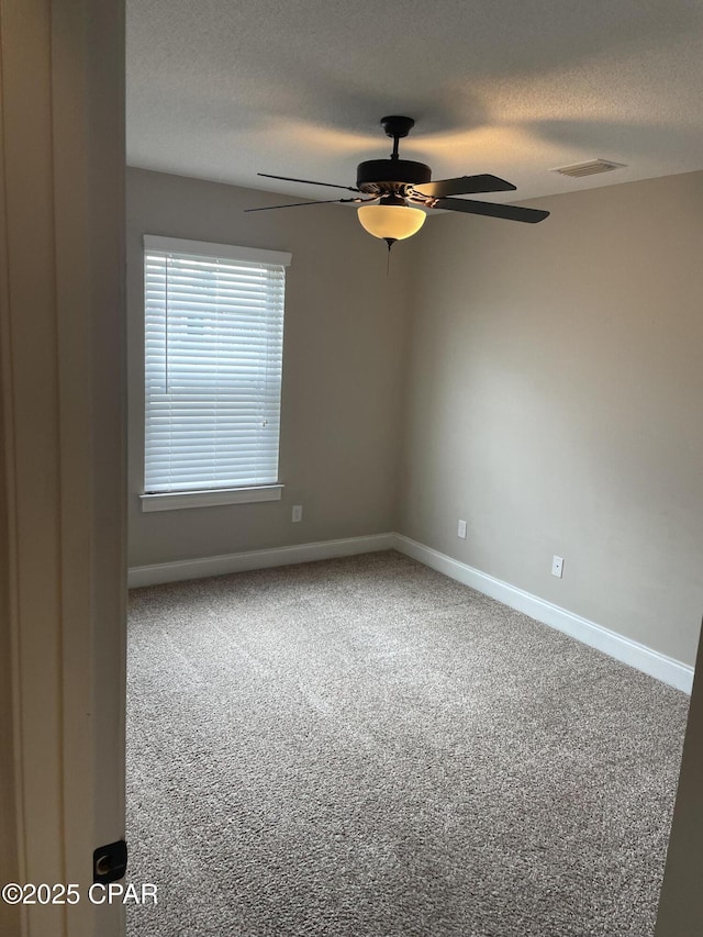 spare room featuring ceiling fan, carpet flooring, and a textured ceiling