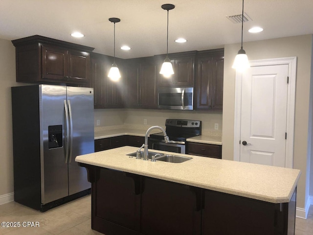 kitchen with dark brown cabinetry, stainless steel appliances, sink, and hanging light fixtures