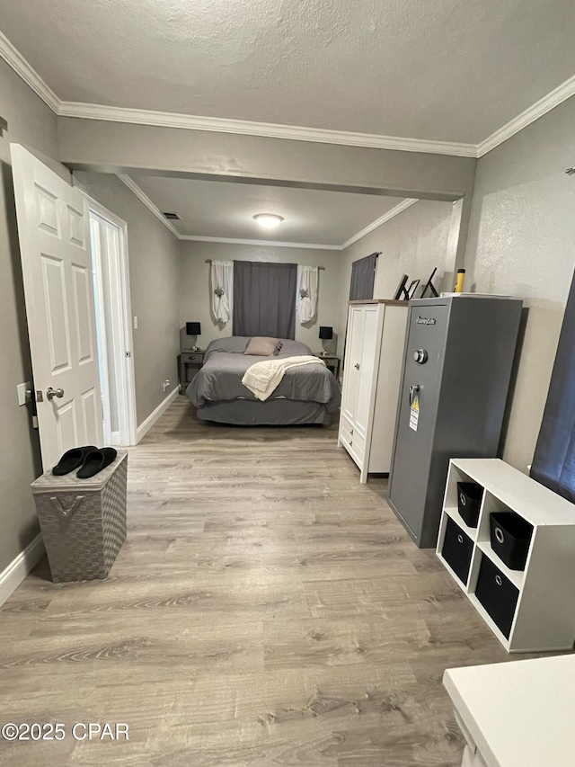 bedroom with crown molding, a textured ceiling, and light hardwood / wood-style flooring