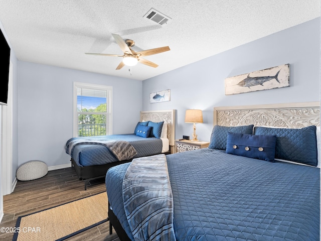 bedroom featuring visible vents, ceiling fan, a textured ceiling, and wood finished floors